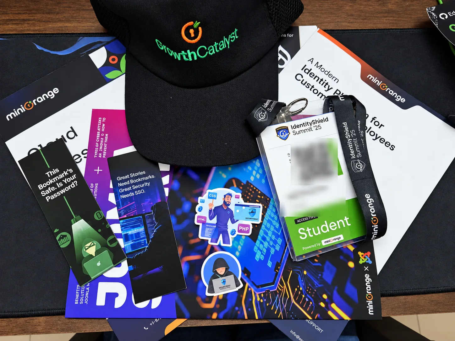An IDS ’25 attendee kit on a desk: cap, badge and lanyard, bookmarks, stickers and brochures