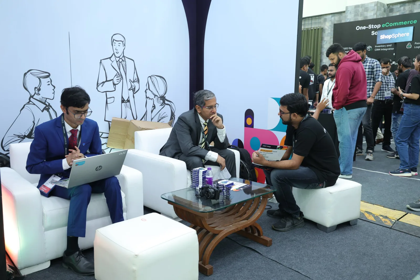 Inside the hub: a meeting on white sofas in front of a line-drawn wall