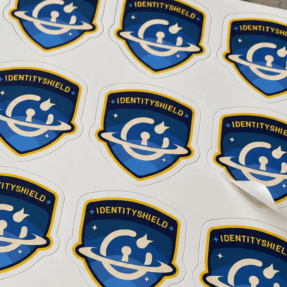 A sheet of Identity Shield logo stickers with one corner peeling