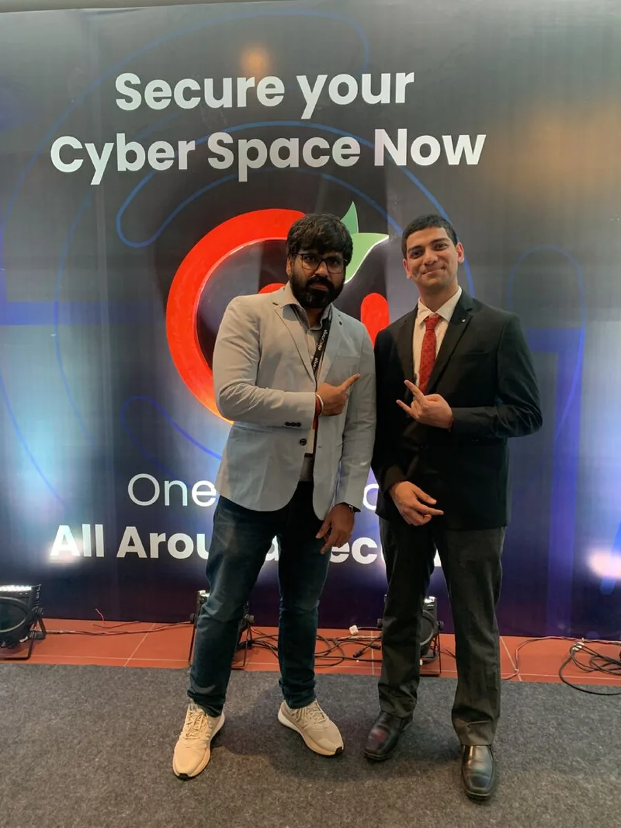 Two men posing in front of the Secure your Cyber Space Now panel